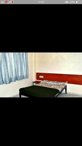 a bedroom with a green bed and a window at SAIRATNA HOTEL only 1 minute distance from sai temple in Shirdi