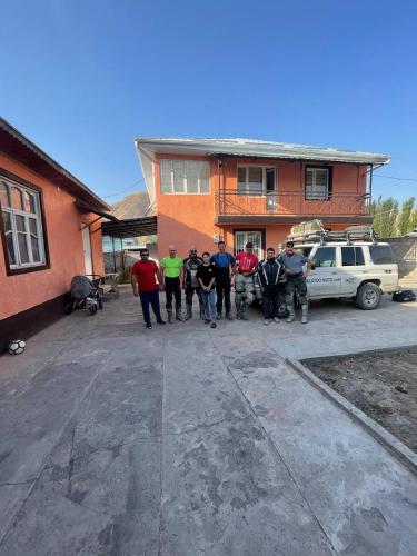 a group of people standing in front of a house at Gulcha in Gultscha