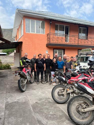 a group of people standing in front of a house with motorcycles at Gulcha in Gultscha