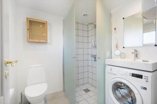 a bathroom with a washing machine and a toilet at 172-Ringkobing-Magedalen-34 in Ringkøbing