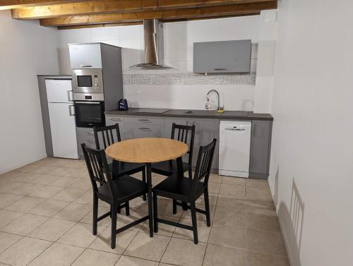 a kitchen with a wooden table and chairs in it at Location maison de bourg in Poncin