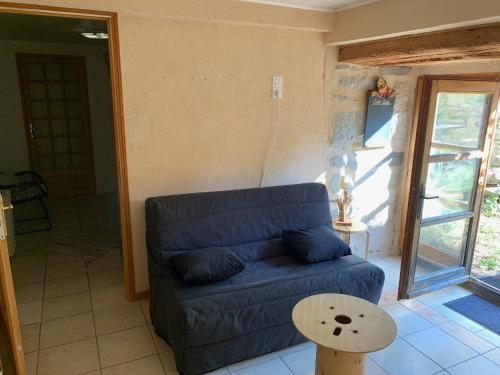 a living room with a blue couch and a table at Domaine Au Vert Gna ! in Saint-Hostien