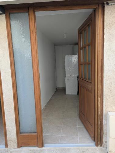 a door leading to a laundry room with a washing machine at Location maison de bourg in Poncin