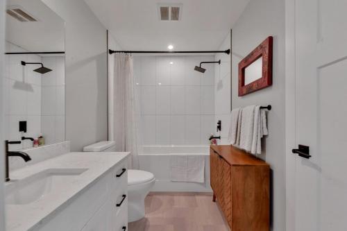 a white bathroom with a sink and a toilet at Harrison Hot Springs Lakeside in Harrison Hot Springs