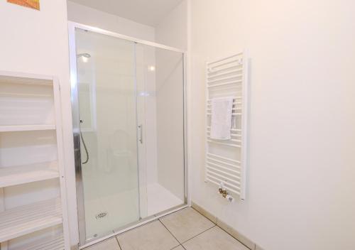 ein Bad mit einer Dusche und einer Glasduschkabine in der Unterkunft Appartement Villa Losa in Biscarrosse