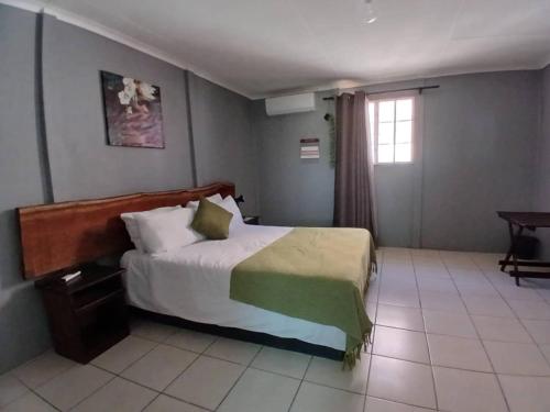 a hotel room with a bed and a window at Carlo's Mountain Lodge in Usakos
