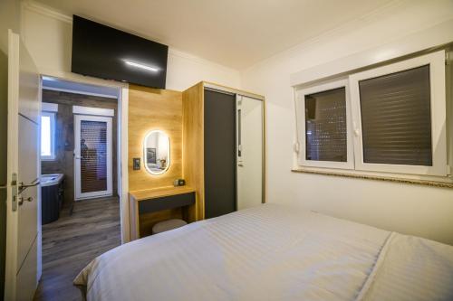 a bedroom with a bed and a television on the wall at Apartmani Petra i Tea in Krapina