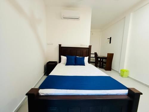 a bedroom with a large bed with blue pillows at Seven Shape Resort - Talalla in Talalla