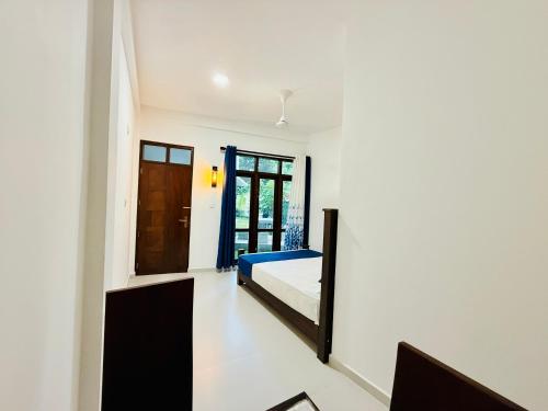 a bedroom with a bed and a door at Seven Shape Resort - Talalla in Talalla