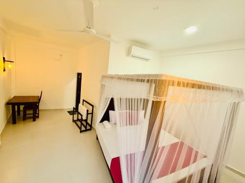 a bedroom with a bed and a table in a room at Seven Shape Resort - Talalla in Talalla
