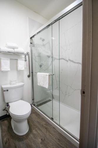 a bathroom with a toilet and a glass shower at The Tillamook Inn in Tillamook