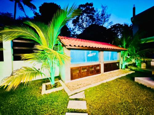 a small house with a palm tree in front of it at Seven Shape Resort - Talalla in Talalla