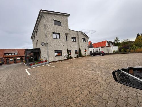 a large brick building with a car parked in a parking lot at Grand Hotel in Soltau