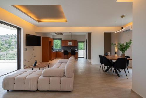 a living room with a couch and a table at White Sand Loutraki Villa - Sea View in Loutraki