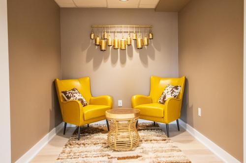 two yellow chairs and a table in a room at The Tillamook Inn in Tillamook