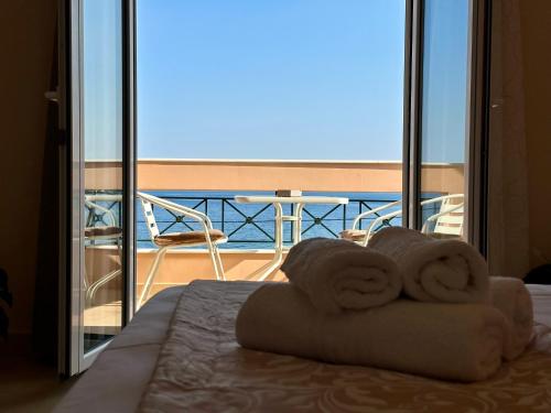 a hotel room with a balcony with a bed and towels at Agali Studios 2 in Gialtra