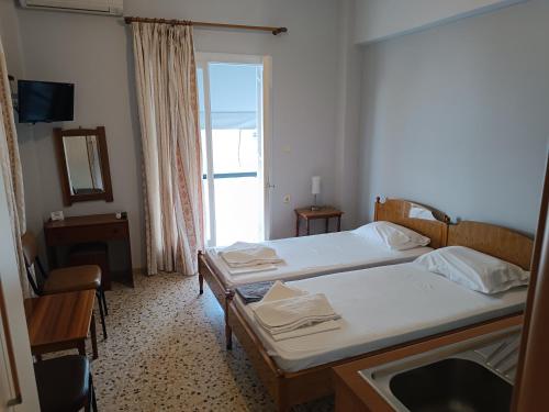 a hotel room with two beds and a window at ARETI in Nafplio