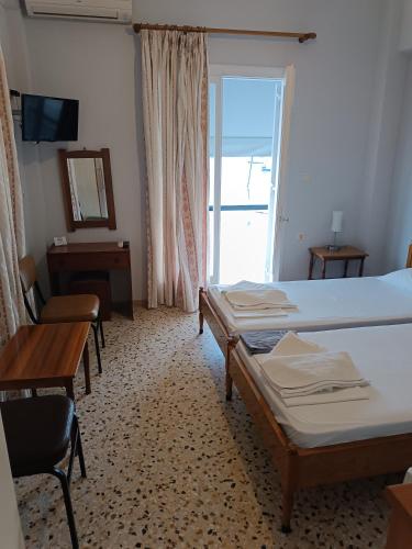 a room with two beds and a desk and a mirror at ARETI in Nafplio
