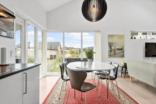 a kitchen and dining room with a table and chairs at 1130-Ringkobing-Sletten-18 in Ringkøbing