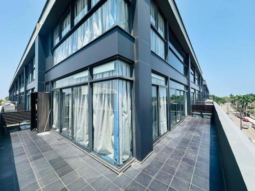 a blue building with glass windows on a sidewalk at Luxurious two Bedroom Apartment at Embassy Gardens in Accra