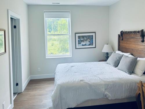 Un dormitorio blanco con una cama grande y una ventana. en Burk Fall view 3B3B, en Burks Falls