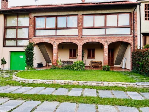 Una casa de ladrillo con una puerta verde y un patio. en Il Gelsomino - Terrace Country House, en Pisano