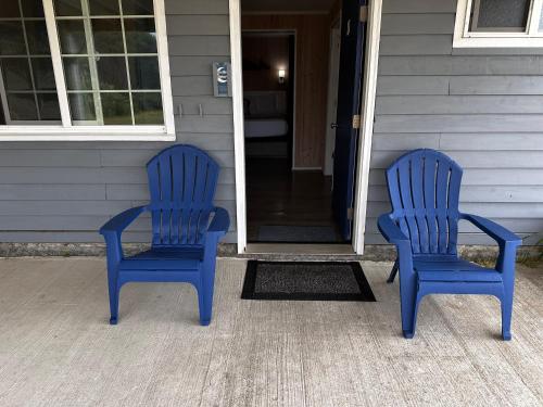 two blue chairs sitting on the porch of a house at Tillicum Beach Motel - Formerly Deane's Oceanfront Lodge in Yachats