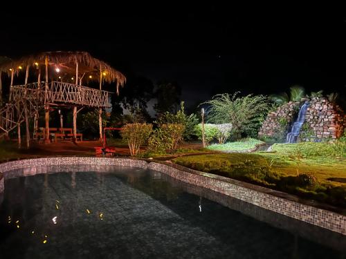 a night view of a garden with a pond at Khet - A Rural Farmstay in Jagdalpur