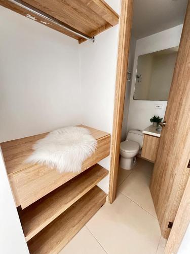 ein Badezimmer mit einem Bett mit Toilette und Spiegel in der Unterkunft Rest and Perfect Location in Dosquebradas