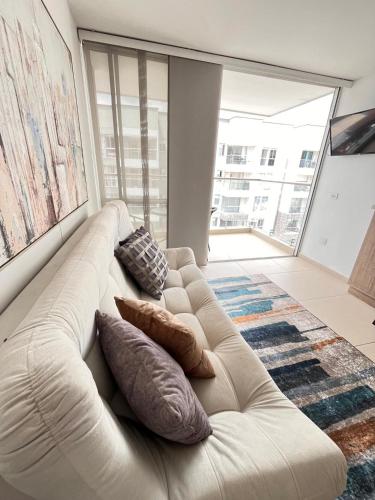 a white couch sitting in a living room with pillows at Rest and Perfect Location in Dosquebradas