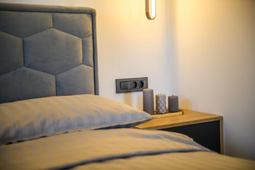 a bedroom with a bed with a headboard and a night stand at Apartmani Petra i Tea in Krapina
