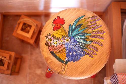 a wooden plate with a rooster painted on it at Gocakapı Datça Dört in Datca