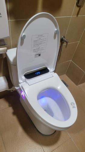 a white toilet with the lid up in a bathroom at Guan Gong Hotel Jin Shang Development Jonker Street in Malacca