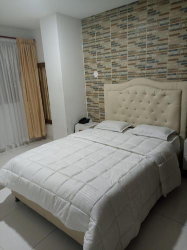 a bedroom with a large bed and a brick wall at San Francisco Plaza Real in Bucaramanga