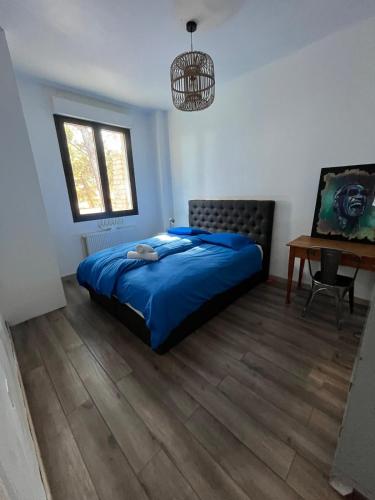 - une chambre avec un lit bleu et un bureau dans l'établissement Villa Bocoumajour, à Carry-le-Rouet