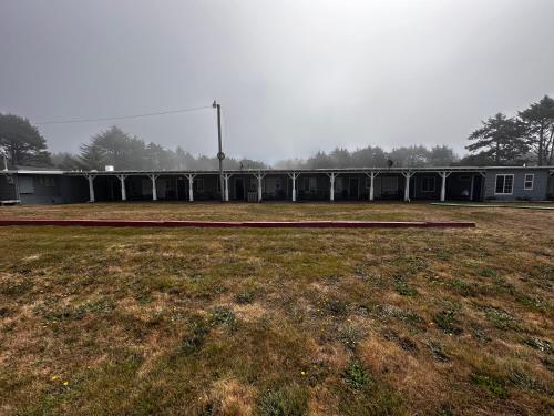 an empty field with a building in the background at Tillicum Beach Motel - Formerly Deane's Oceanfront Lodge in Yachats