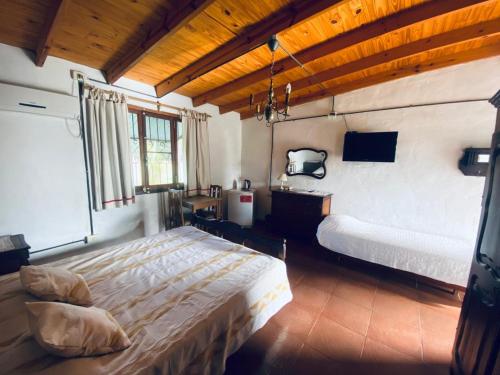 een slaapkamer met 2 bedden en een tv. bij Posada Rio Tala in Río Tala