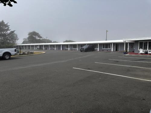 an empty parking lot in front of a building at Tillicum Beach Motel - Formerly Deane's Oceanfront Lodge in Yachats