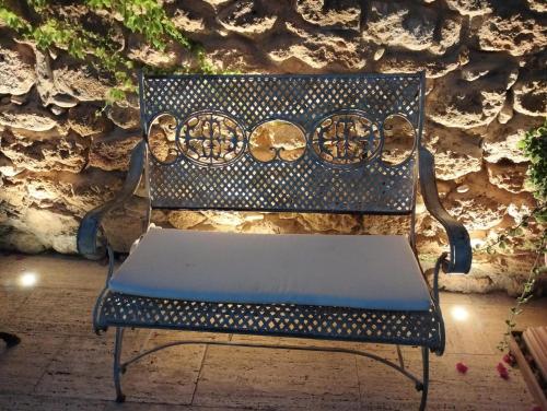 a blue chair sitting in front of a stone wall at Hotel Foresteria Baglio Della Luna in San Leone