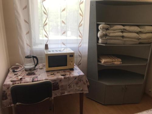 un microondas sentado en una mesa en una habitación en Окремий номер, en Chernivtsi