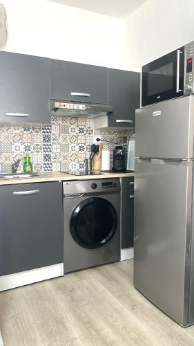 une cuisine avec un lave-linge et un réfrigérateur dans l'établissement belle de mai marseille centre studio, à Marseille