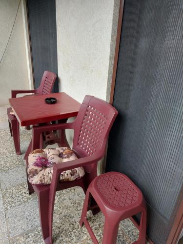 two red chairs and a red table and a stool at Apartmani Breza in Vrdnik