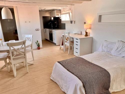 a bedroom with a bed and a table and a kitchen at Downtown Dreams in Madrid