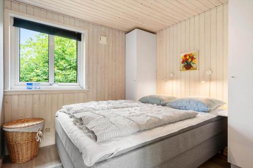 een groot bed in een kamer met een raam bij 1134-Ringkobing-Egernvej-12 in Nørby