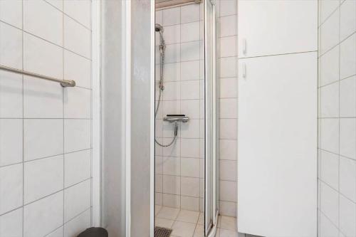 een douche in een wit betegelde badkamer bij 1134-Ringkobing-Egernvej-12 in Nørby