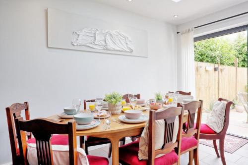 a dining room with a wooden table and chairs at Beautiful 5 bed house, relaxing garden and driveway parking 10 min to the beach in Southend-on-Sea