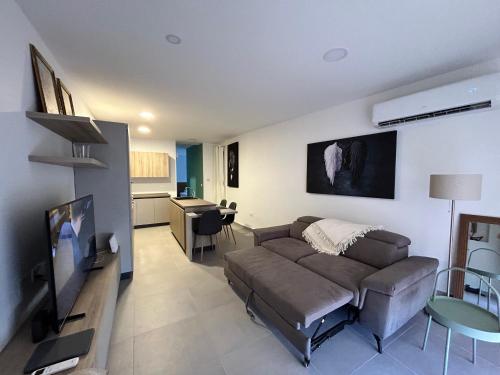 マルサシュロックにあるStylish Seaside 1br Maisonette Marsaxlokk Bayのリビングルーム(ソファ、テレビ付)