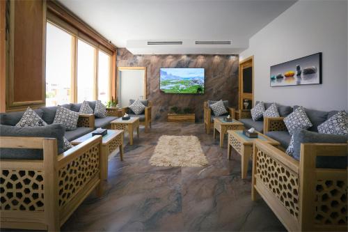 a waiting room with couches and a tv at Aroma Hotel in Aqaba