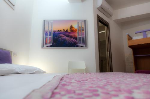 a bedroom with a bed and a picture on the wall at La dimora dei ricci in Santo Stefano di Camastra