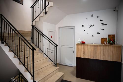 a staircase in a house with a clock on the wall at Pensiunea Adonis in Arefu
